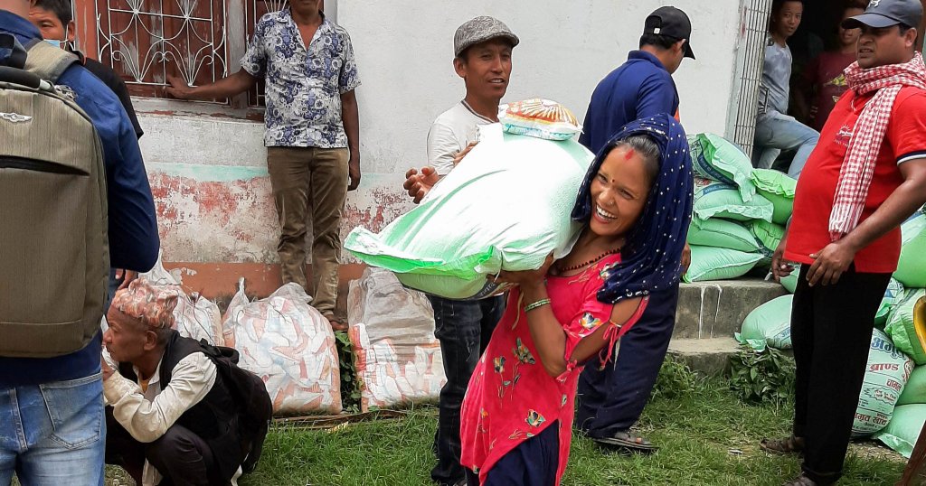 Eine trägt einen 30 Kilogramm schweren Reisbeutel auf ihrer Schulter.